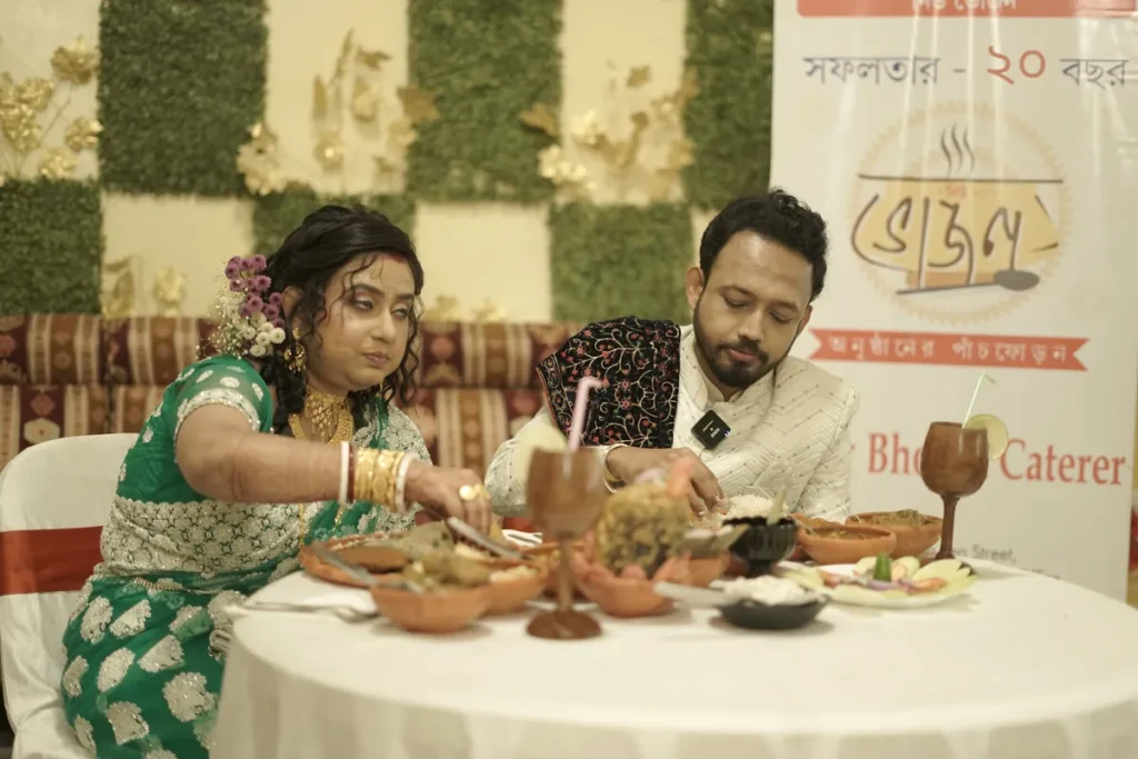 Bride and groom enjoying a Bengali wedding meal served in clay plates by New Bhojon Caterer, Kolkata